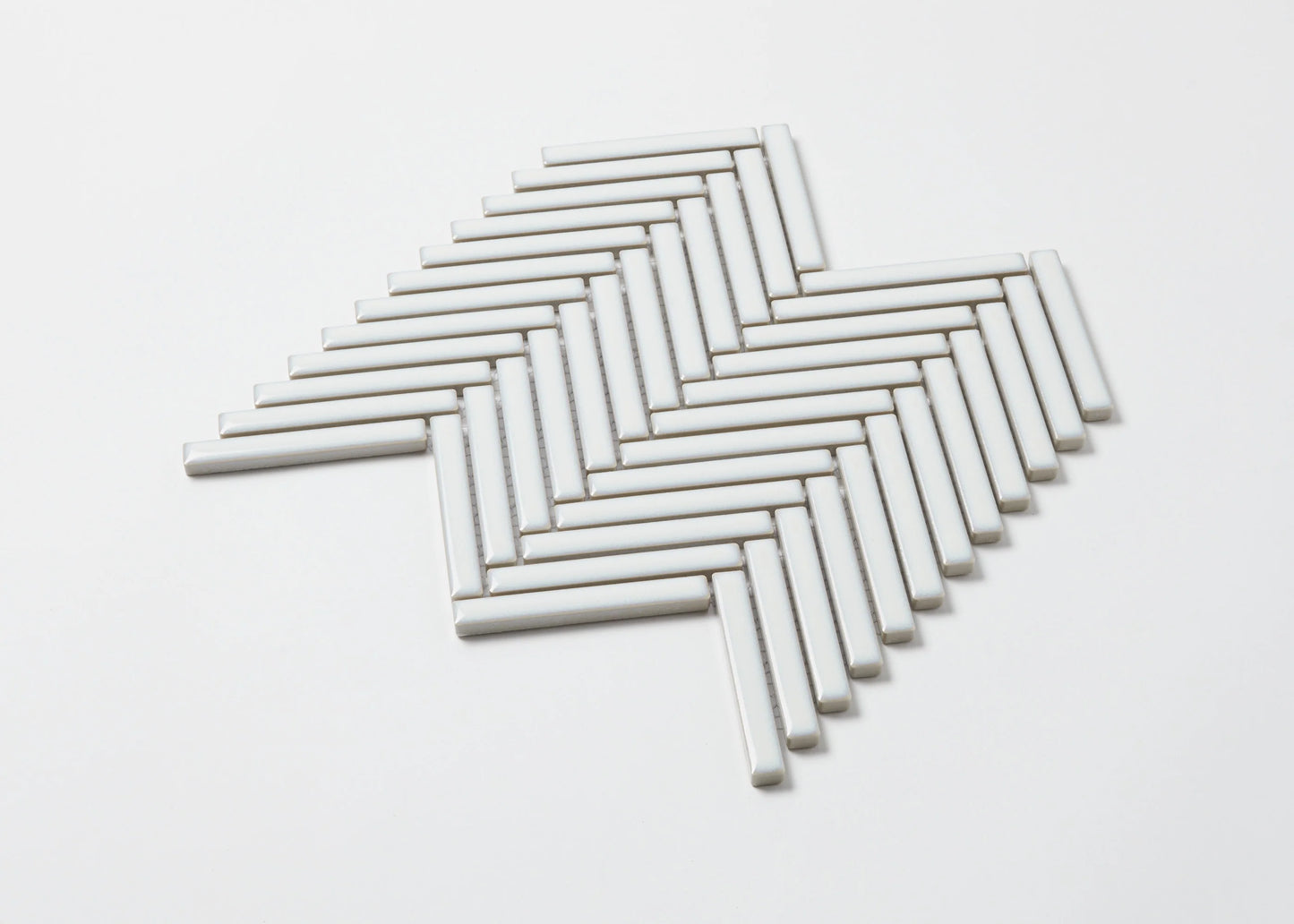 Pack shot of Antique White Gloss Porcelain Glazed Herringbone KitKat 12x92mm tiles arranged in a classic herringbone mosaic pattern on a white background.