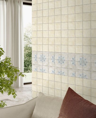 Antiquity Opal 150x150mm cream wall tiles with a decorative blue floral border stripe installed in a bright living room beside sheer curtains and indoor plants.