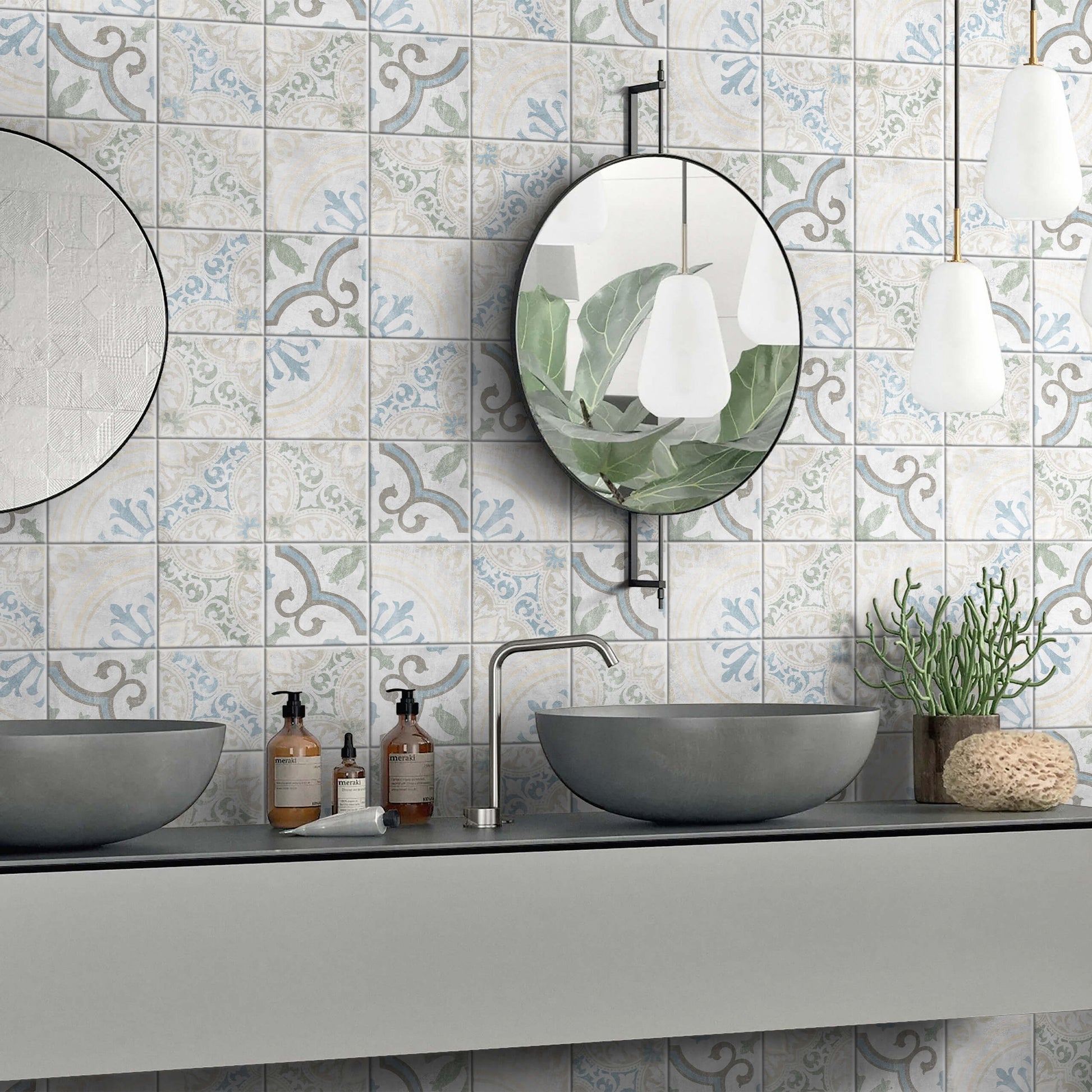 Antiquity Venetian Decor 150x150mm patterned wall tiles in soft blue and grey installed behind a double grey vessel sink vanity with round mirrors and pendant lights.