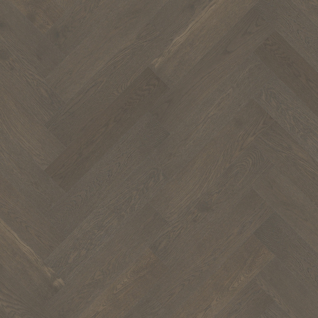 Close-up texture shot of Apollo Grey iDesign Herringbone Flooring 15/3mm showing dark grey oak wood grain in a diagonal herringbone pattern.