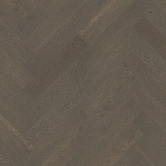 Close-up texture shot of Apollo Grey iDesign Herringbone Flooring 15/3mm showing dark grey oak wood grain in a diagonal herringbone pattern.