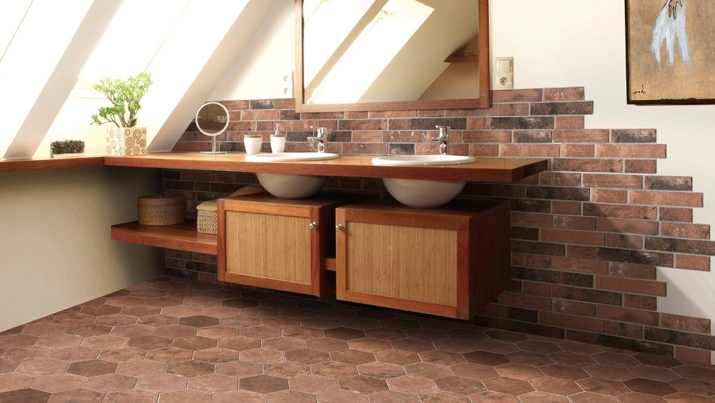 Argille Rame 160x400mm brick-effect terracotta tiles covering a bathroom vanity wall and hexagonal floor, styled with a timber double vanity and skylights.