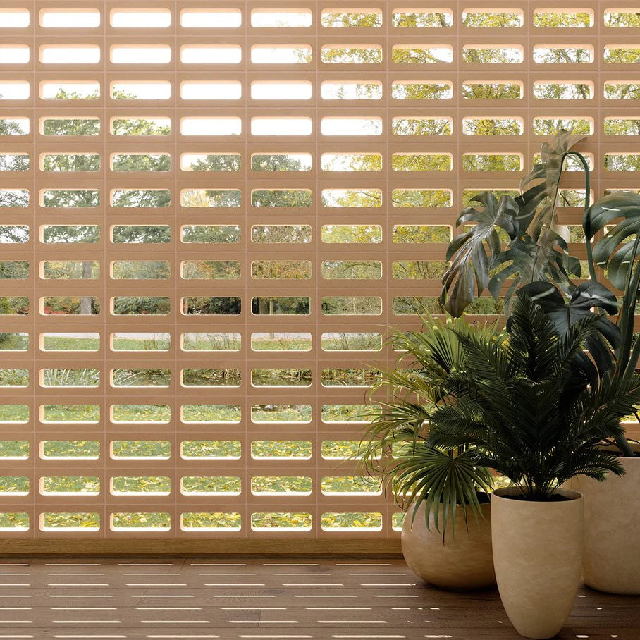 Arialuce Asole Avorio Breeze Blocks 120x240 installed as a perforated ivory screen wall with tropical potted plants on a timber floor.