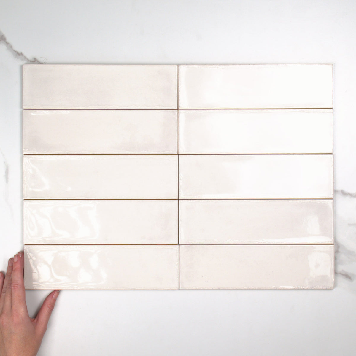 Atlantique Blanc Gloss 69x240mm top view, hand for scale