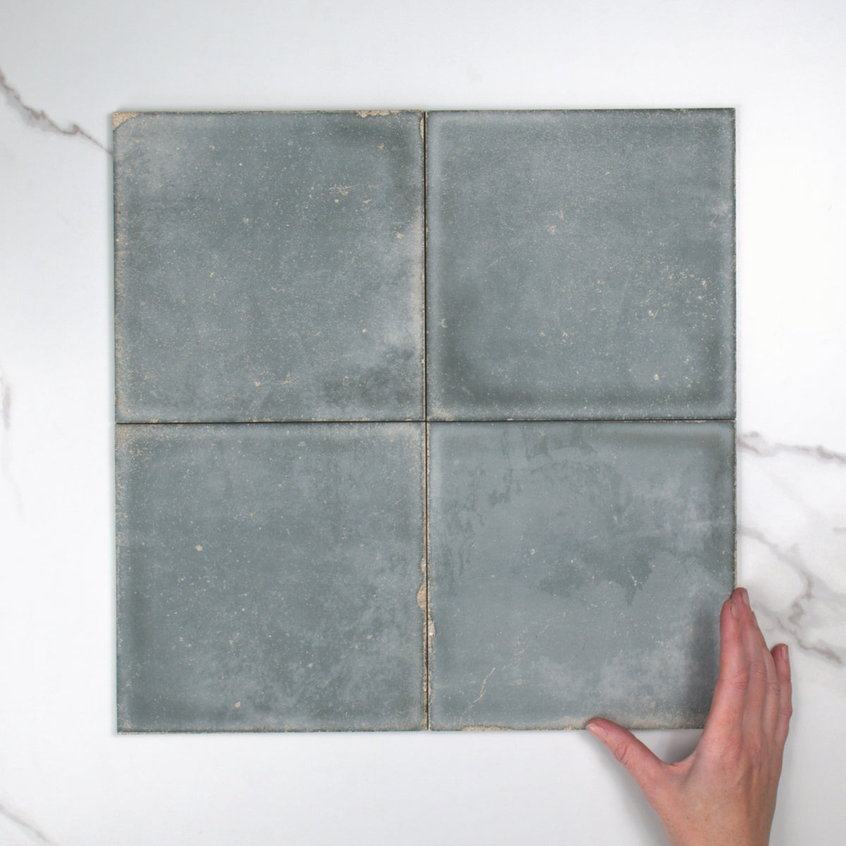 Atlantique Bleu Matt 200x200mm top view, hand for scale