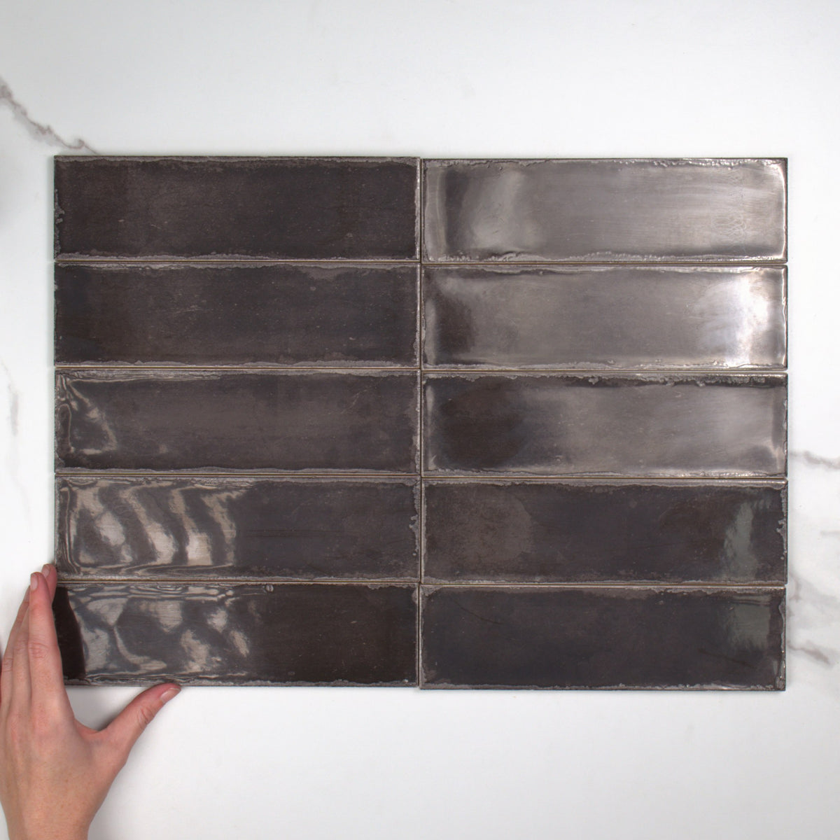 Atlantique Charbon Gloss 69x240mm top view, hand for scale