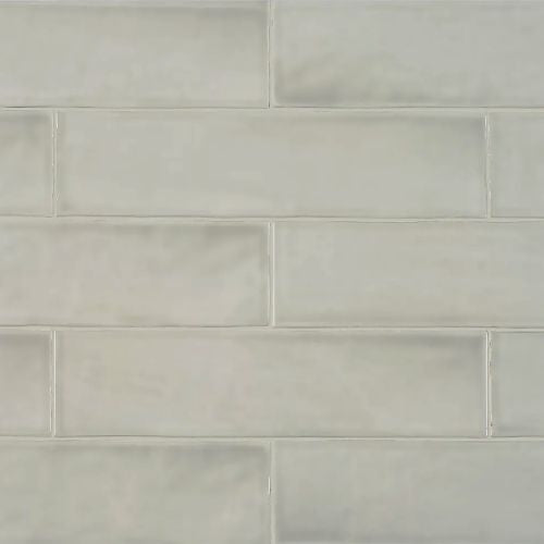 Close-up of Aura Stone Gloss 75x300mm ceramic wall tiles in a soft grey tone with a glossy glazed finish and subtle surface variation arranged in a brick pattern.