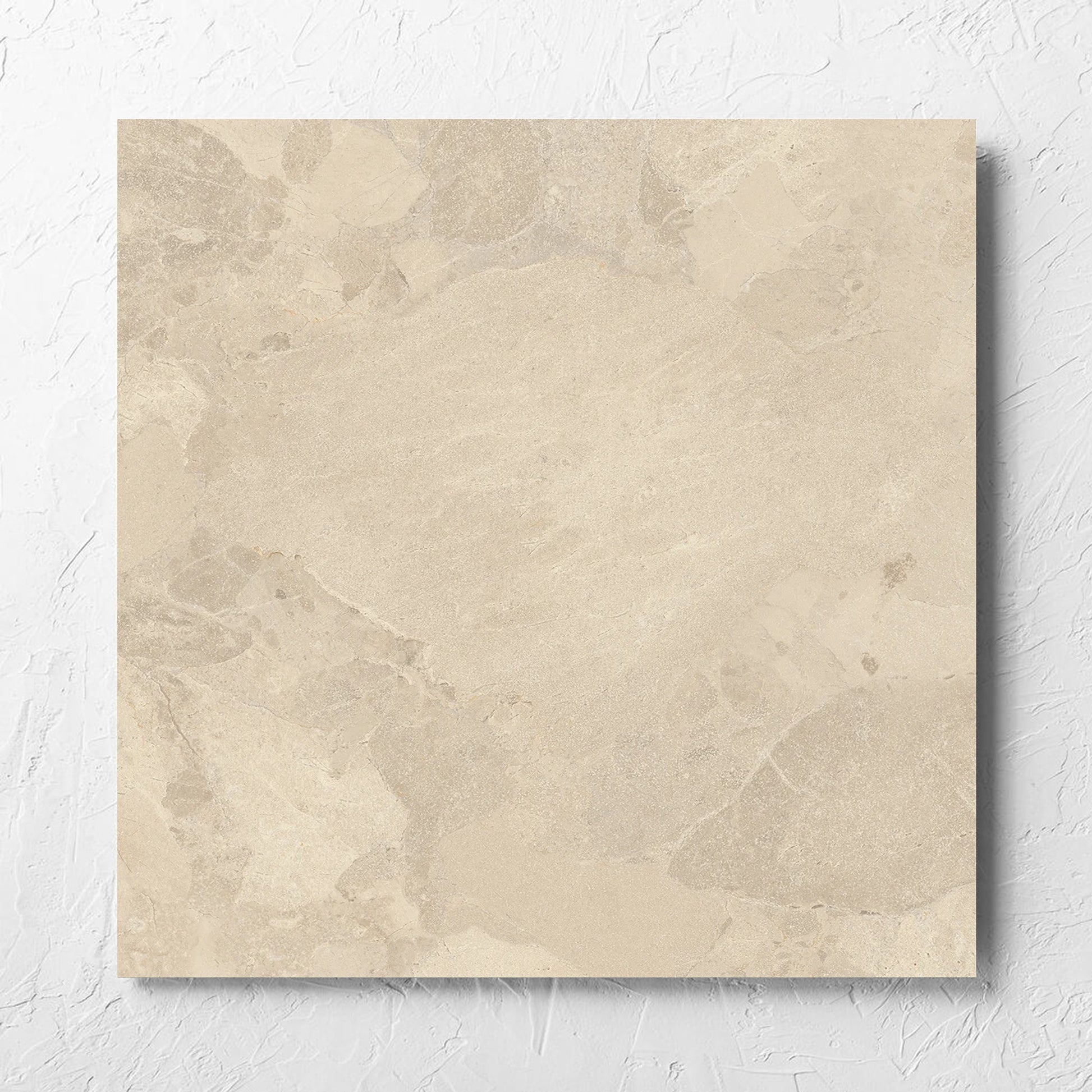 Aurelia Stone Beige Grip 600x600mm tile laid flat on a white rendered wall, showing the matt surface