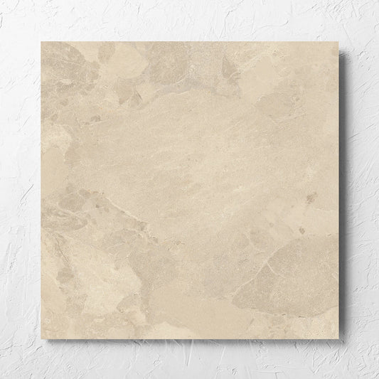 Aurelia Stone Beige Grip 600x600mm tile laid flat on a white rendered wall, showing the matt surface