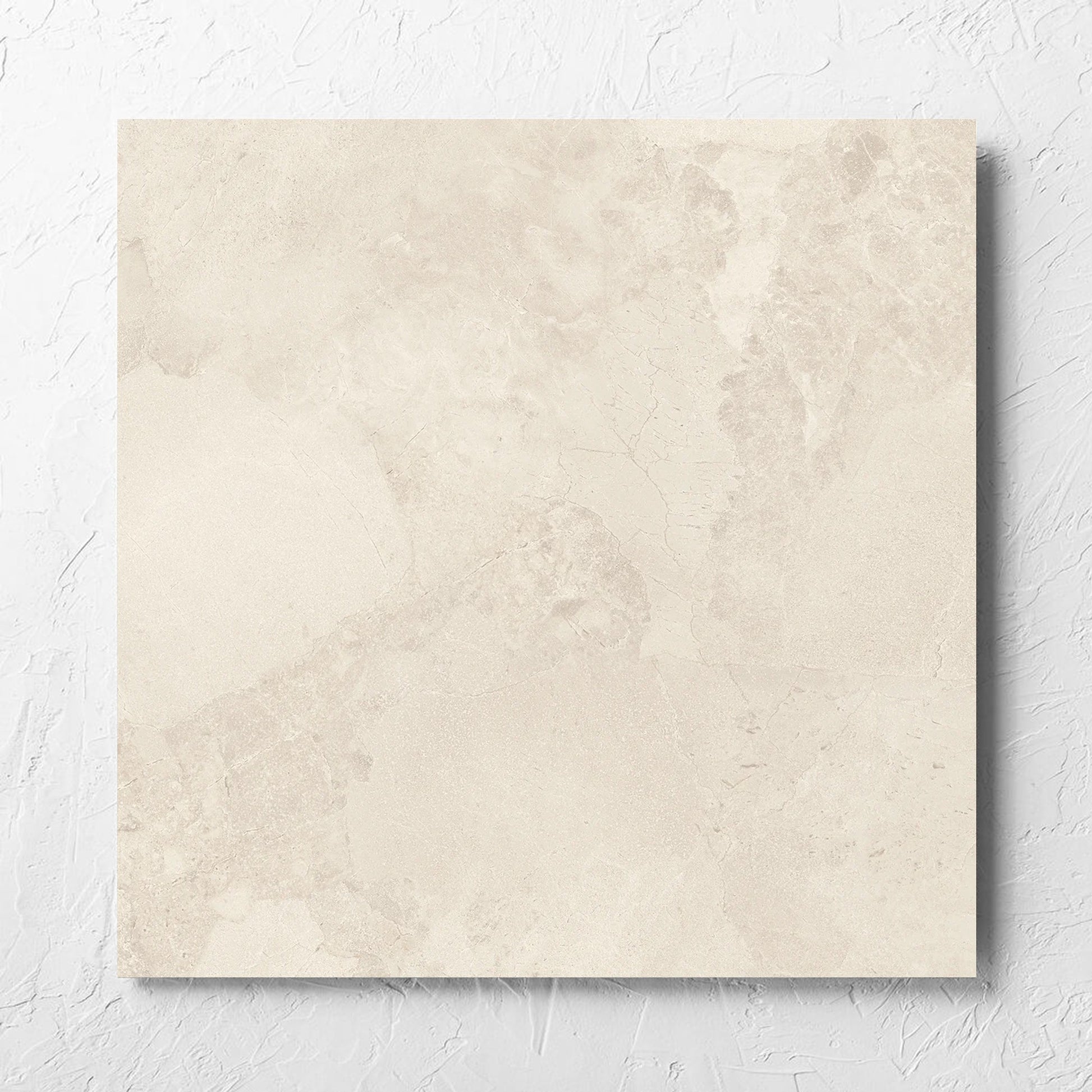 Aurelia Stone White Matt 600x600mm tile laid flat on a white rendered wall, showing the matt surface