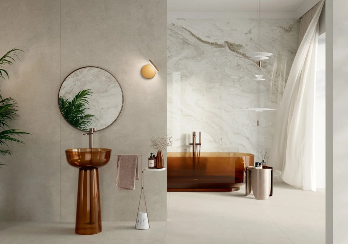 Balance Light Grey Mat 600x600mm tiles installed as floor and wall in a luxury bathroom featuring an amber glass pedestal sink, freestanding copper bathtub, and marble feature wall.