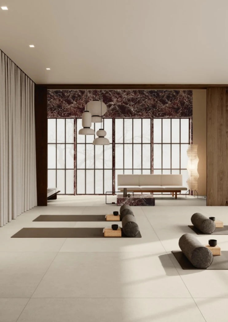 Balance Light Grey Mat 600x600mm large-format floor tiles installed in a minimalist yoga studio with pendant lights and floor-to-ceiling windows.