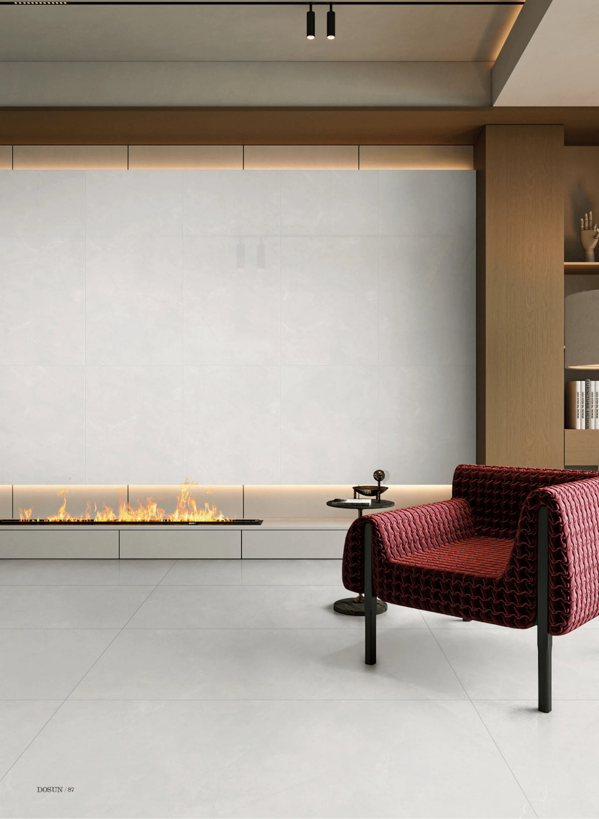 Beton Grey Matt 300x600mm tiles installed as a large-format feature wall and floor in a contemporary living room with a linear fireplace and burgundy armchair.