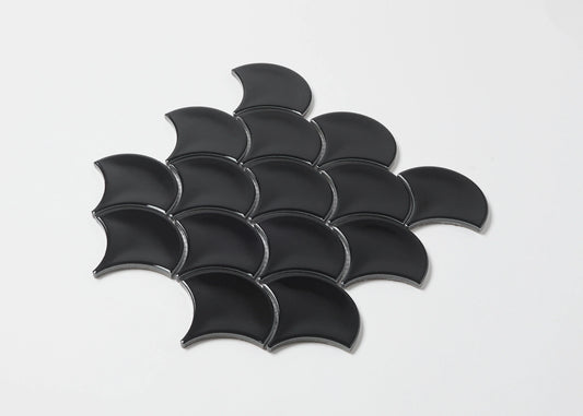 Pack shot of Black Gloss Glazed Porcelain Fishscale 95x87mm tiles arranged in an overlapping scale pattern, showcasing their curved fan shape and glossy black finish.