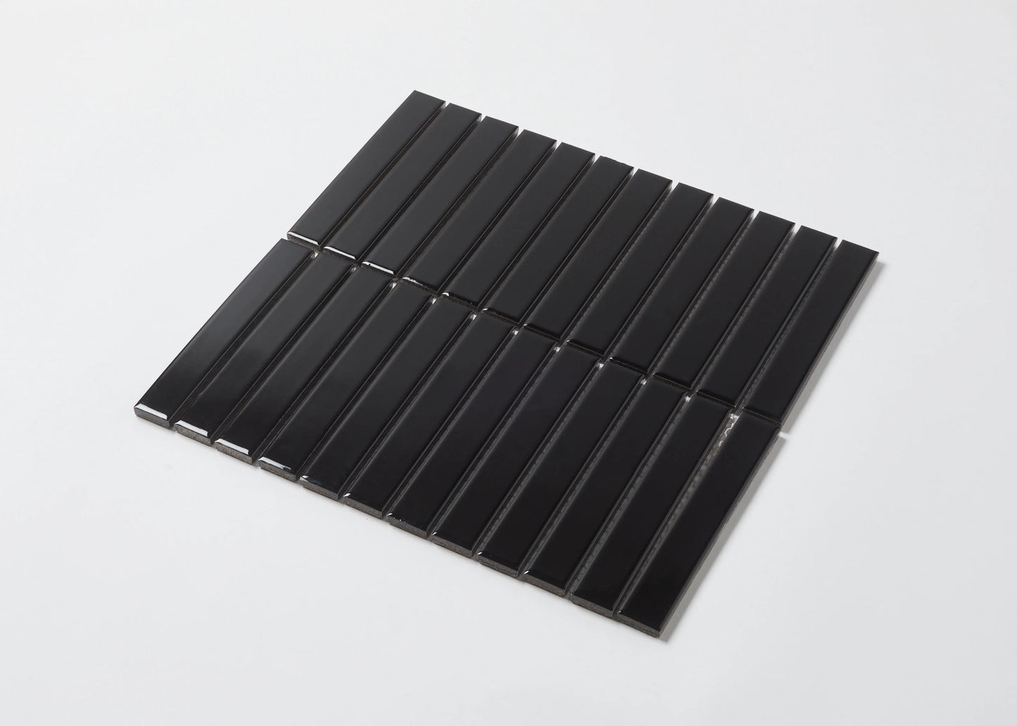 Pack shot of Black Gloss KitKat Straight Bone Pattern 22x145mm tiles arranged in vertical parallel strips on a white background.