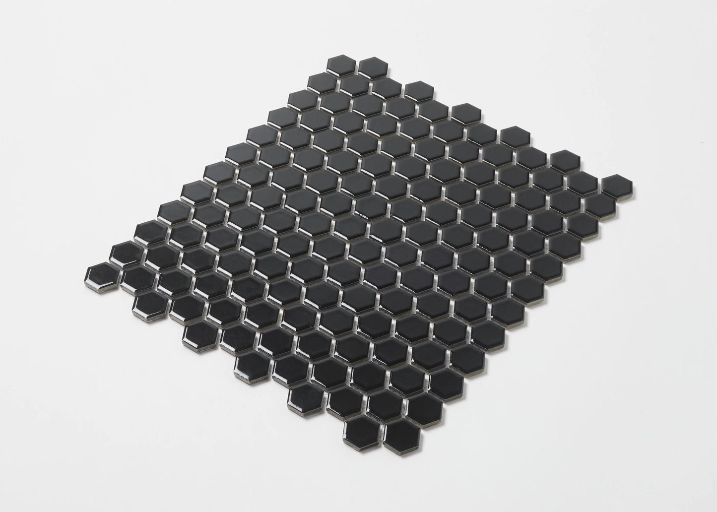 Pack shot of Black Gloss Porcelain Glazed Hexagon 23mm mosaic tile sheet showing a uniform grid of small glossy black hexagonal tiles on mesh backing.