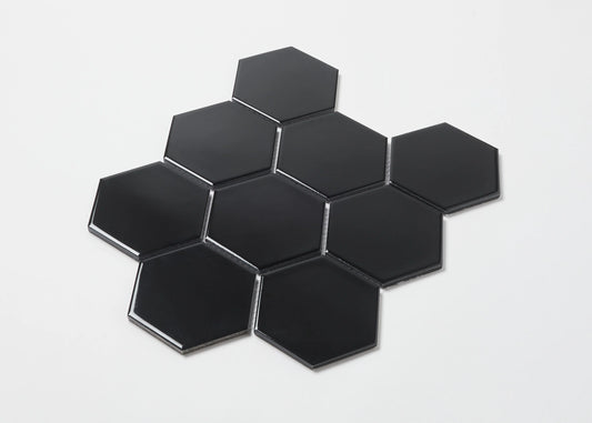 Pack shot of Black Gloss Porcelain Glazed Hexagon 95x110mm tiles arranged in a honeycomb cluster showing glossy black finish and bevelled edges.