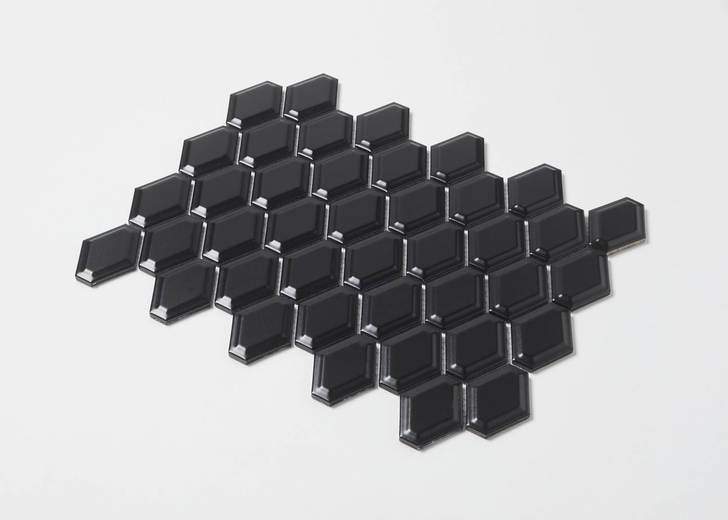 Pack shot of Black Matte External Porcelain Glazed Honeycombe 46.5x60mm tiles arranged in a diamond cluster, showcasing their bevelled edges and matte black finish.
