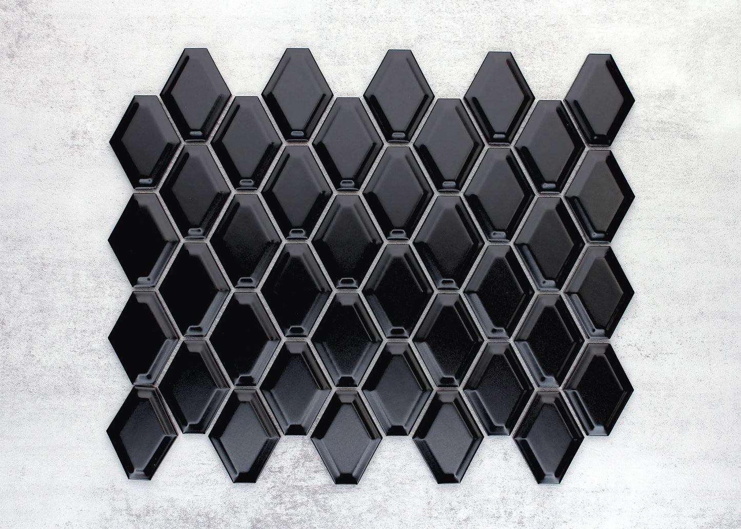 Close-up of Black Matte External Porcelain Glazed Honeycombe 46.5x60mm tiles arranged in a full sheet, showing glossy black elongated hexagon shapes with bevelled edges and grey grout lines.