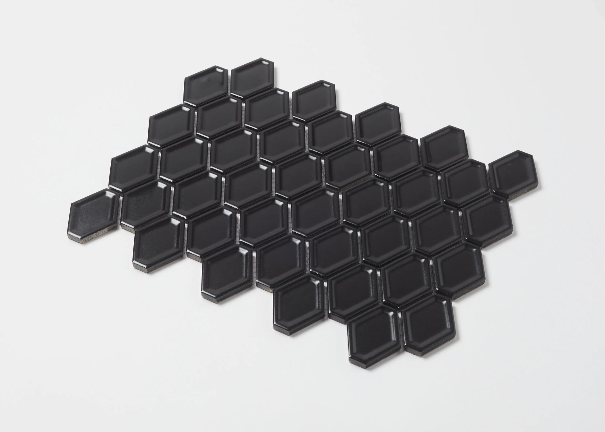 Pack shot of Black Matte Internal Porcelain Glazed Honeycombe 46.5x60mm tiles arranged in a honeycomb pattern, showing bevelled edges and matte black finish.