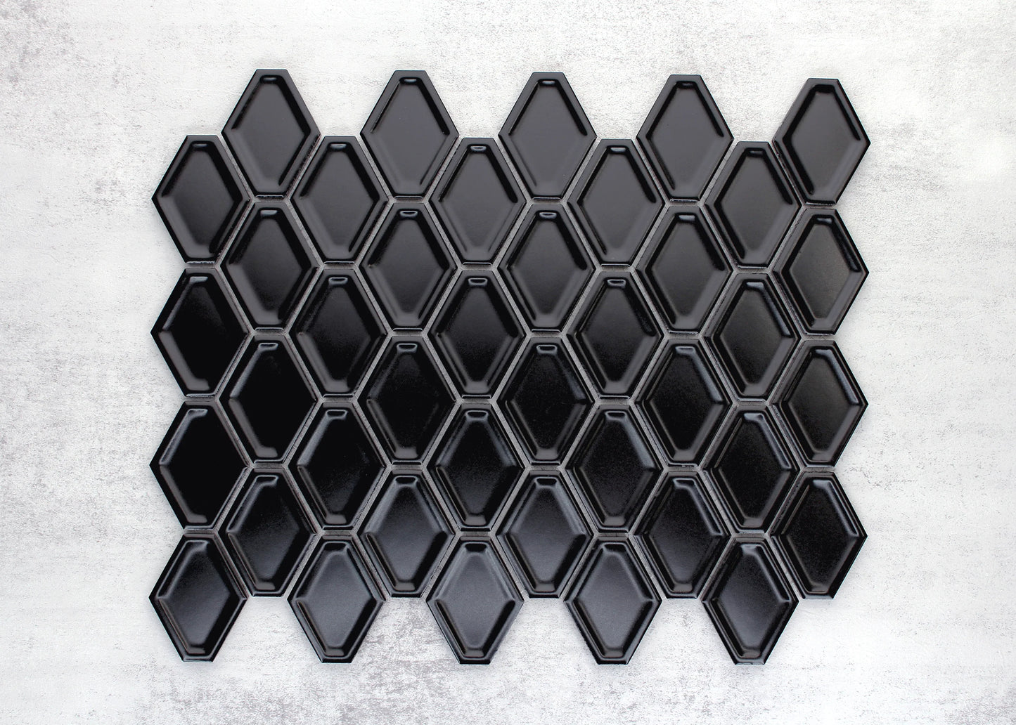 A mosaic sheet of Black Matte Internal Porcelain Glazed Honeycombe 46.5x60mm tiles showing bevelled diamond-shaped pieces in a glossy black finish arranged in an interlocking pattern.