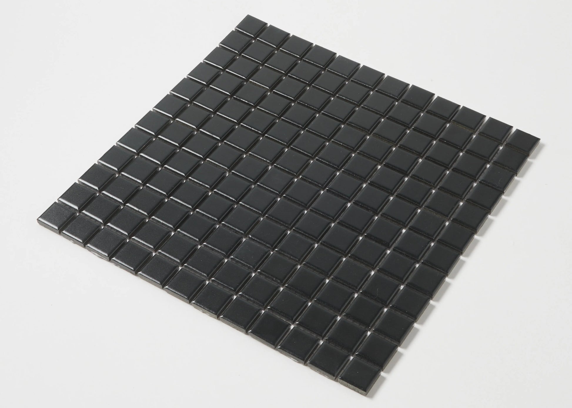Pack shot of Black Matte Porcelain Glazed 23mm Square mosaic tile sheet showing uniform matte black finish and grid-spaced small square tiles.