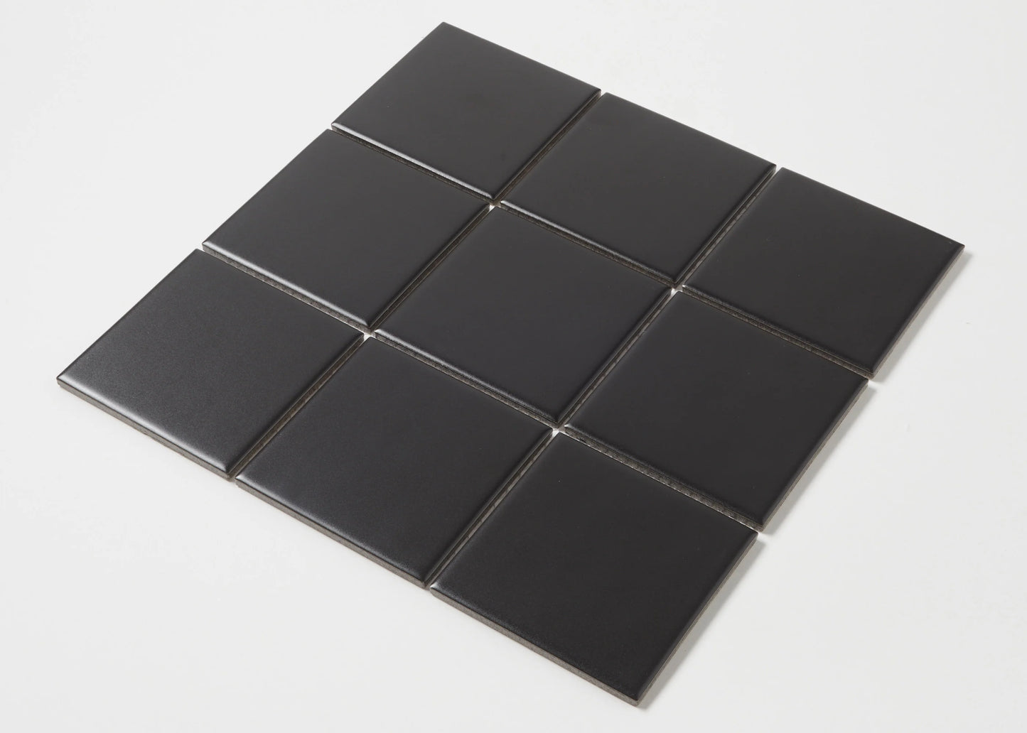 Nine Black Matte Porcelain Glazed 97x97mm Square tiles arranged in a 3x3 grid, showcasing the smooth matte black finish and square format.