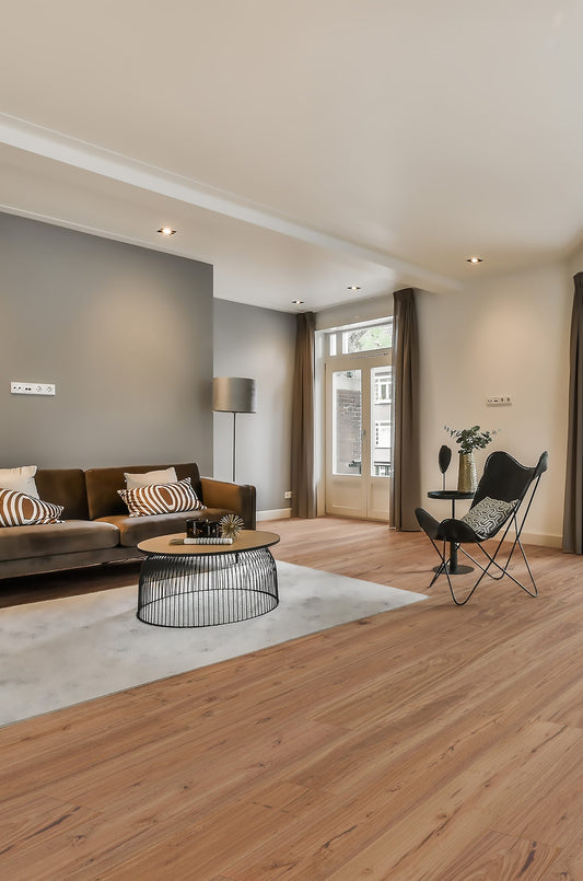 Blackbutt Rustic Grade Engineered Australian Classic Flooring 14/3mm installed in a contemporary living room featuring a brown sofa, butterfly chair, and round wire coffee table.