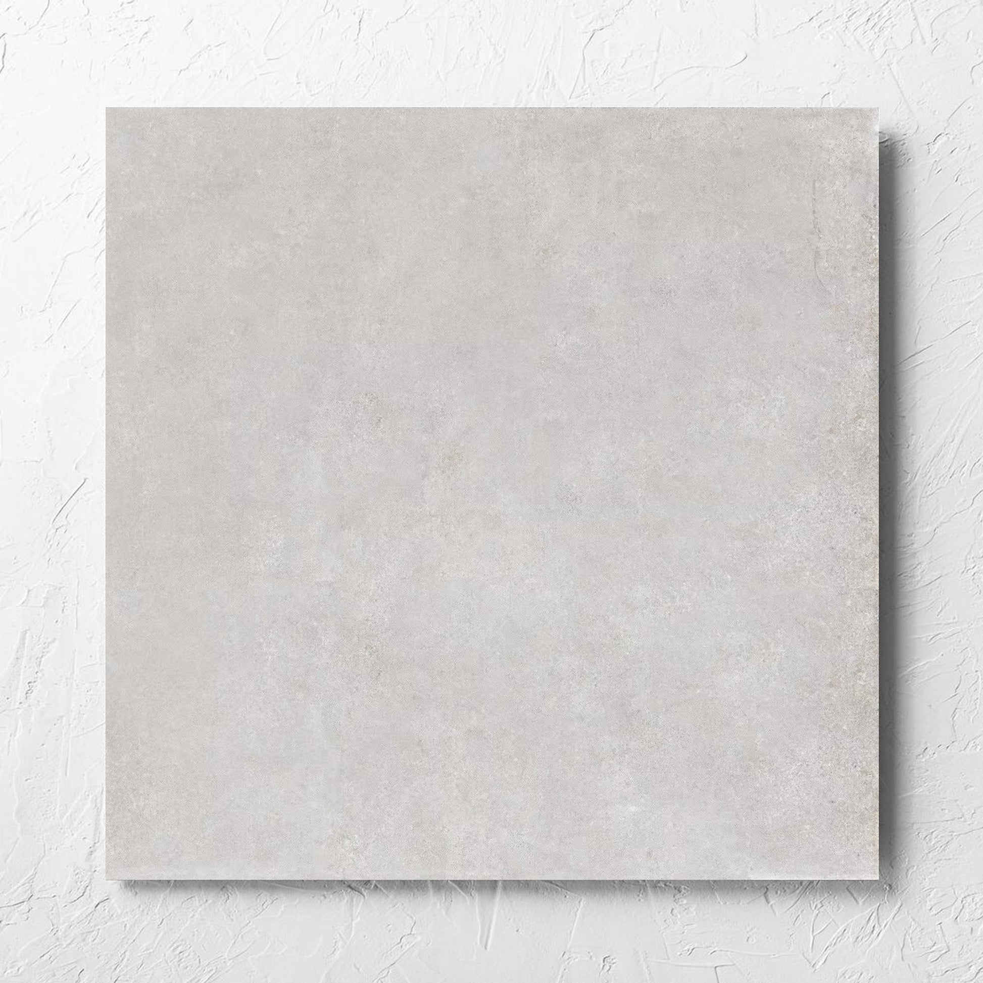 Boston Silver Matt 600x600mm tile laid flat on a white rendered wall, showing the tile surface