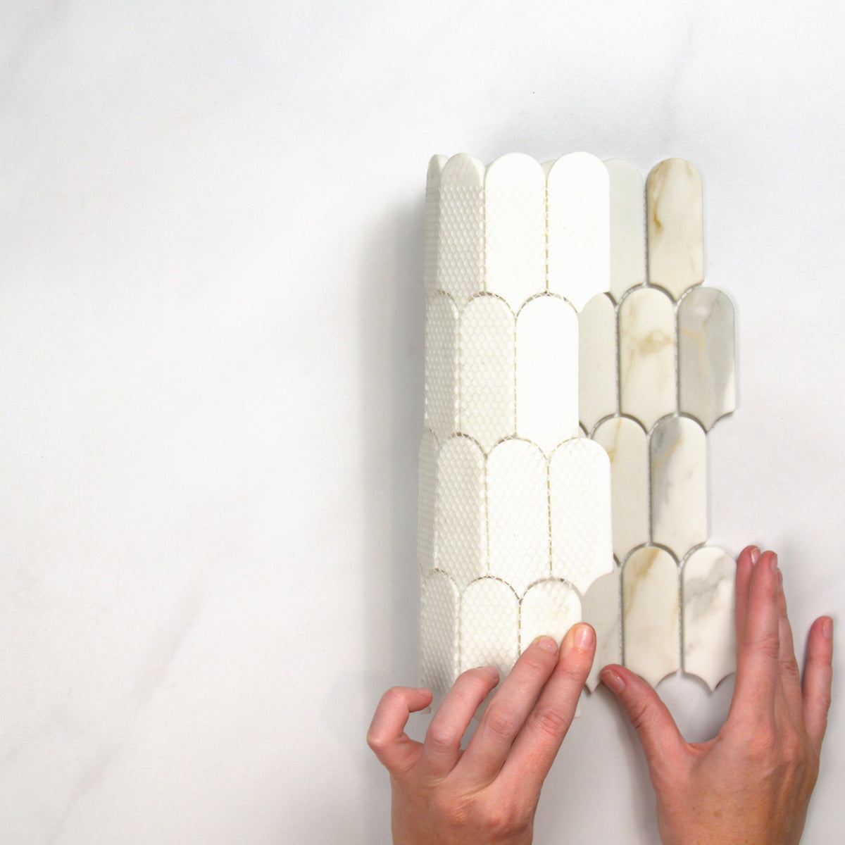 Boutique Calacatta Gold Mix Recycled Glass Feather 258x298mm top view, hand for scale
