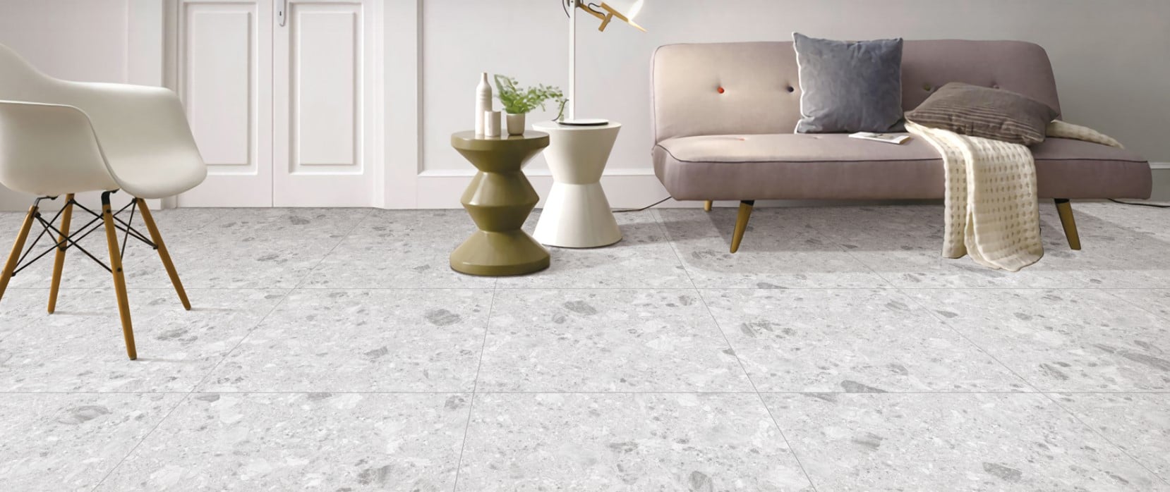 Breccia Light Grey 600x600mm porcelain floor tiles installed in a modern living room with a blush sofa, Eames chair, and sculptural side tables.