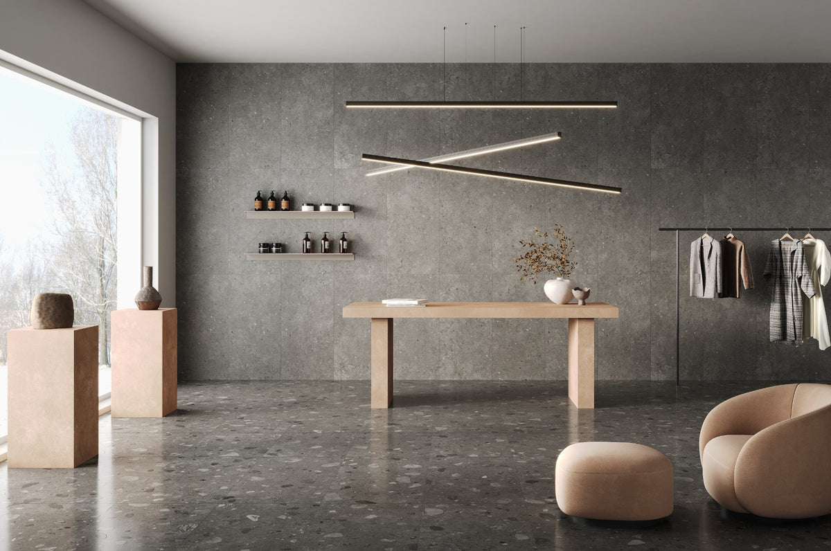 Brescia Iconic Grafite Premium Honed 600x1200mm tiles covering a full-height feature wall in a contemporary retail boutique with pendant lighting and timber display table.