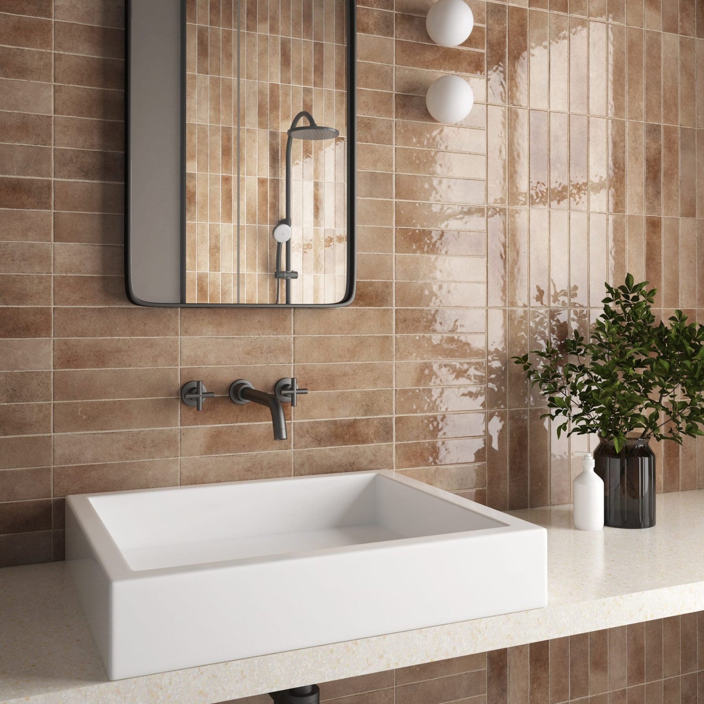 Bricks Cotto Gloss 60x246 warm terracotta glazed wall tiles installed vertically in a modern bathroom with a white vessel sink and black-framed mirror.