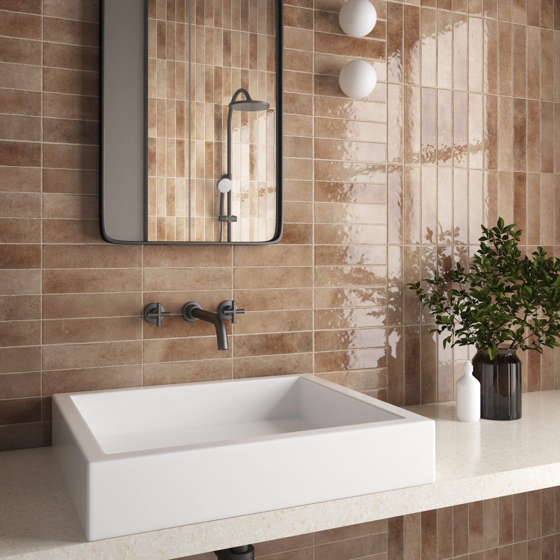 Bricks Cotto Gloss 60x246 warm terracotta glazed wall tiles installed vertically in a modern bathroom with a white vessel sink and black-framed mirror.