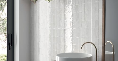 Bricks White Gloss 60x246 tiles installed as a full-height bathroom feature wall behind a freestanding round basin with brushed gold tap.