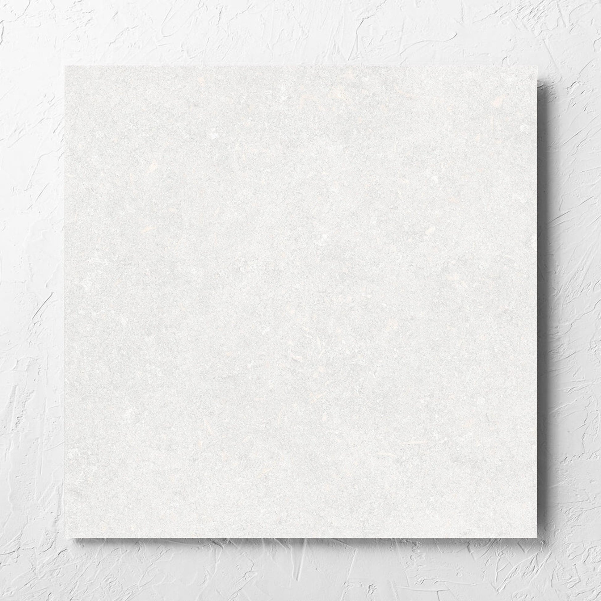 Brighton Bianco Matt 600x600mm tile laid flat on a white rendered wall, showing the matt surface