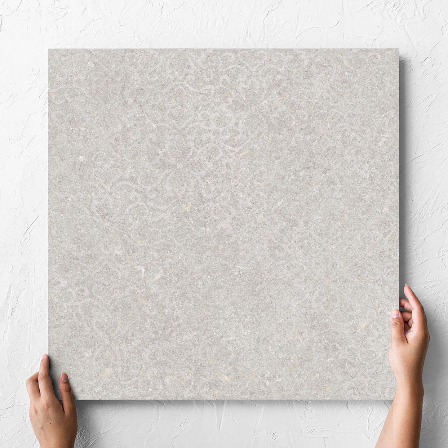 Hand holding a single Brighton Stone Matt 600x600mm tile against a white rendered wall, showing the matt surface