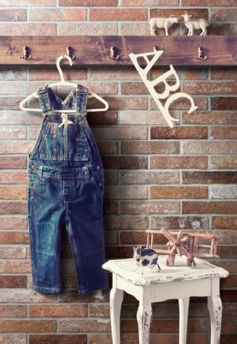 Bristol Red Brick Tile 60x250mm used as a rustic feature wall in a children's nursery, styled with denim overalls, wooden toys, and ABC letters.