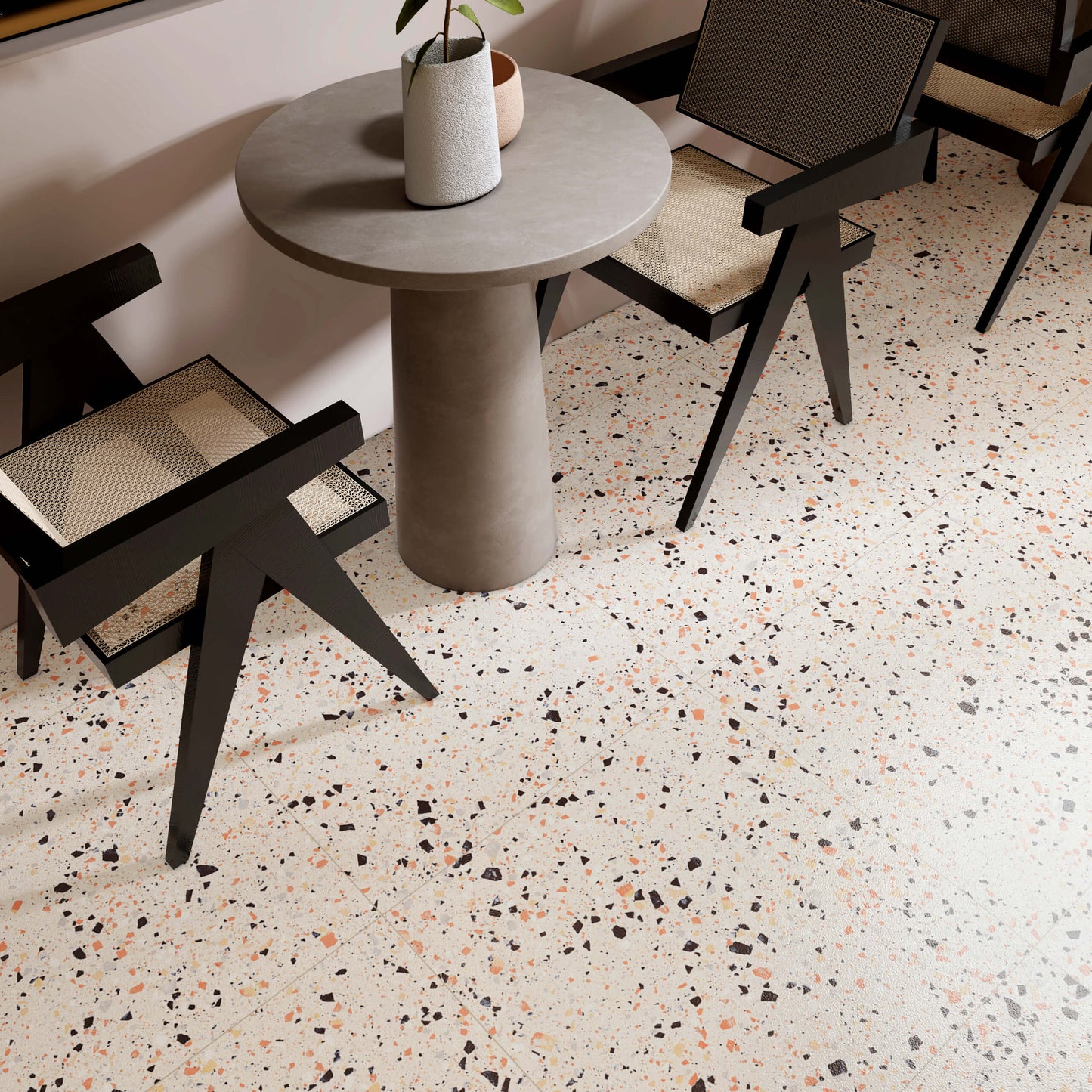 C Venice 300x600 Matt Beige Terrazzo Look Rectified tile installed as a café dining room floor with a round concrete table and black rattan chairs.