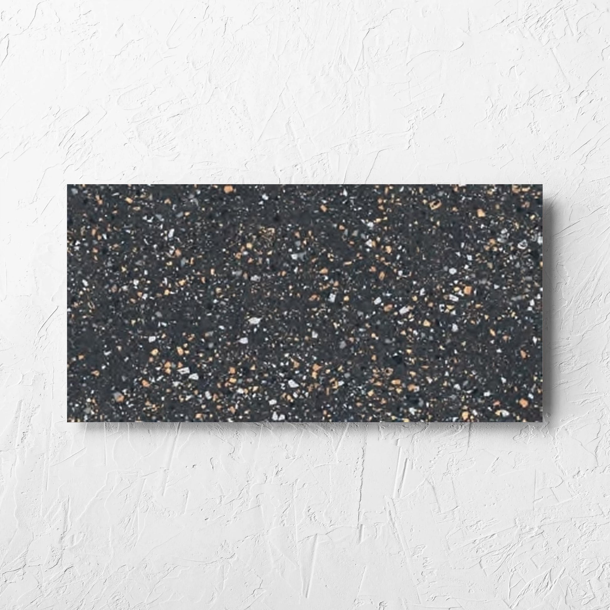 C Venice 300x600 Matt Graphite Terrazzo Look Rectified tile laid flat on a white rendered wall, showing the tile surface