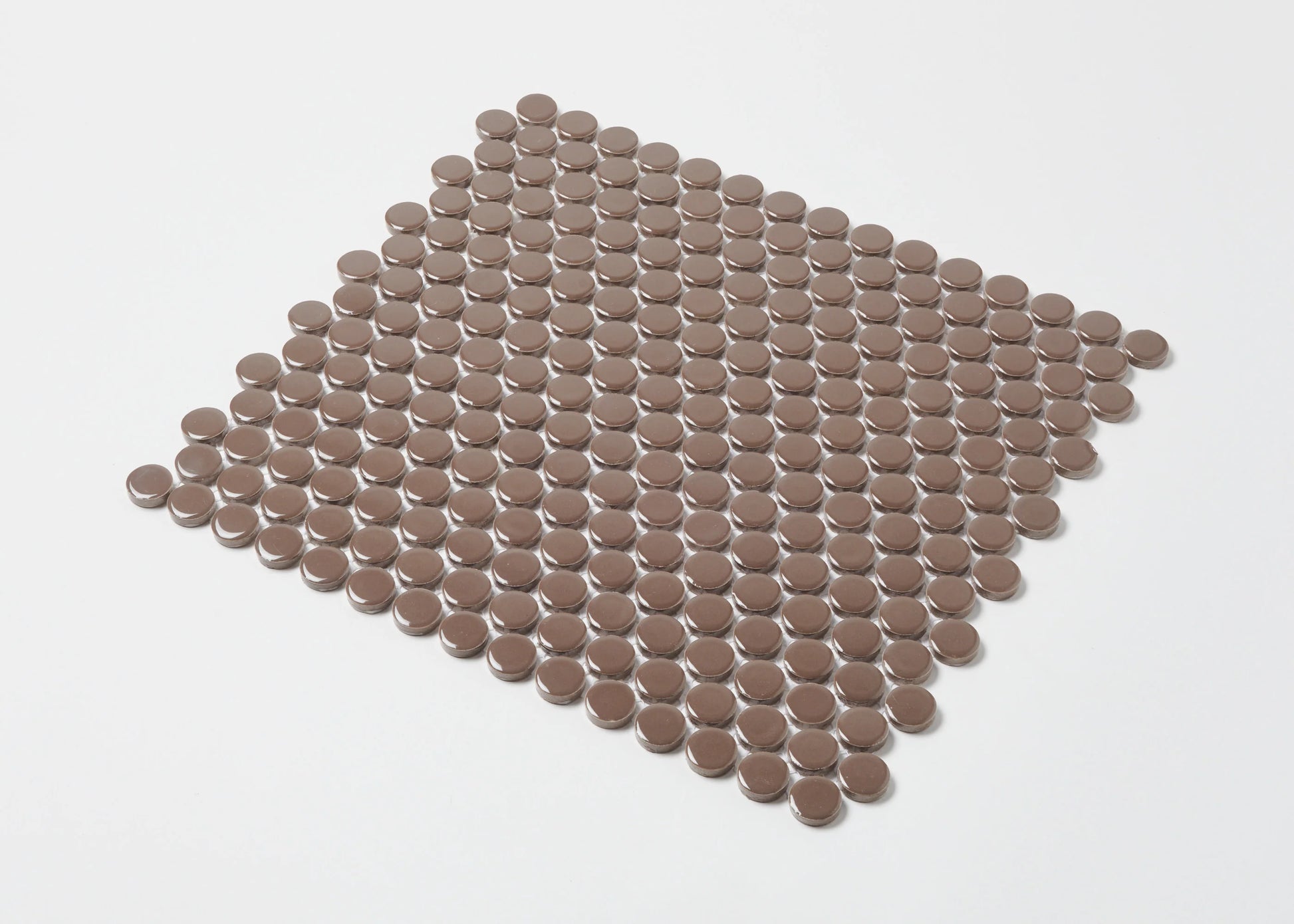 Pack shot of Cappuccino Gloss Diameter Glazed Porcelain Penny Round 19mm tiles arranged in a flat grid, showing warm brown gloss circular mosaic pieces.