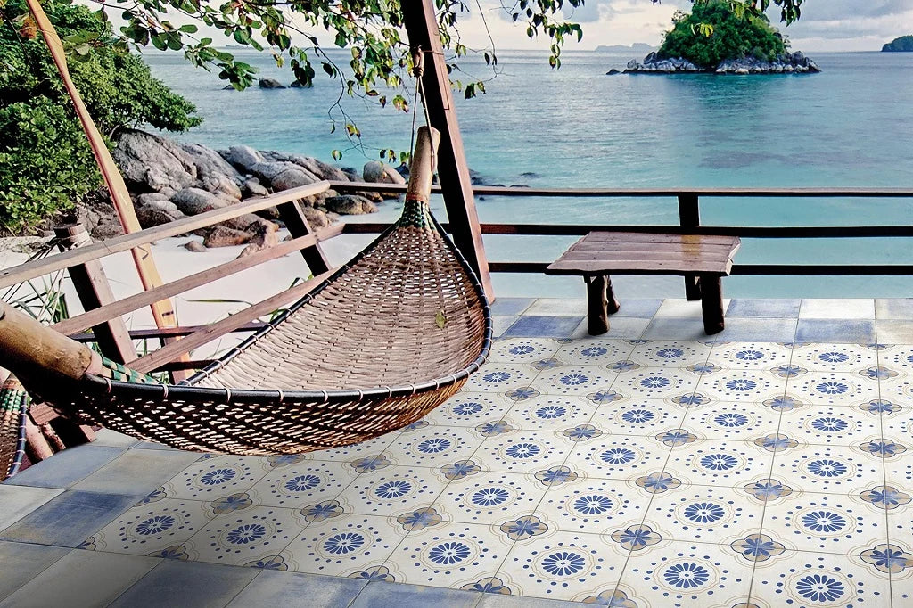 Caribbean Bahamas 205x205mm patterned floor tiles laid on a tropical beachside terrace with a hanging rattan chair and turquoise sea views.