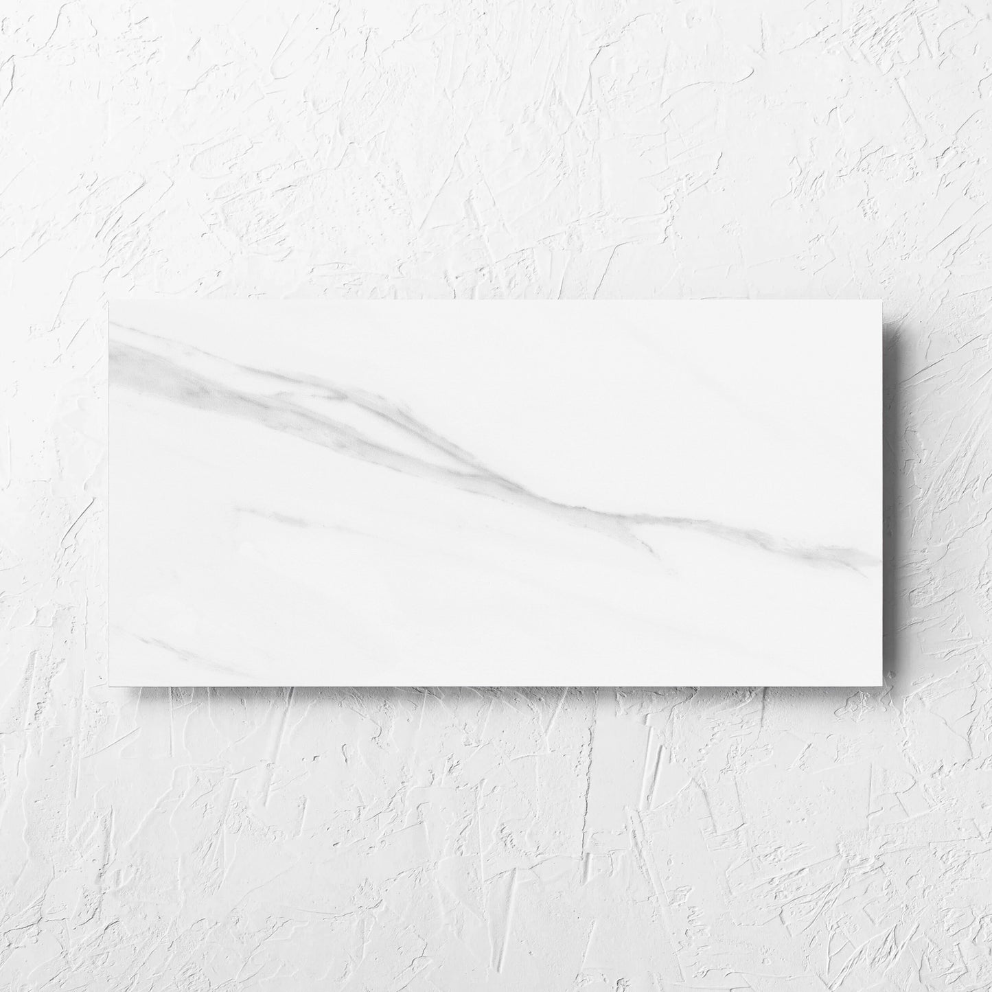 Carrara Bianco Gloss 300x600mm tile laid flat on a white rendered wall, showing the gloss surface