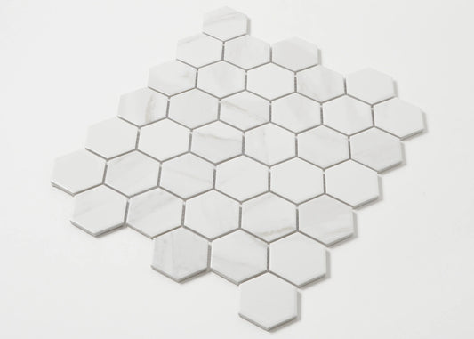 Pack shot of Carrara Look Matte Porcelain Glazed Hexagon 51x59mm tiles arranged in a honeycomb mosaic sheet, showing white matte finish with subtle grey marble veining.