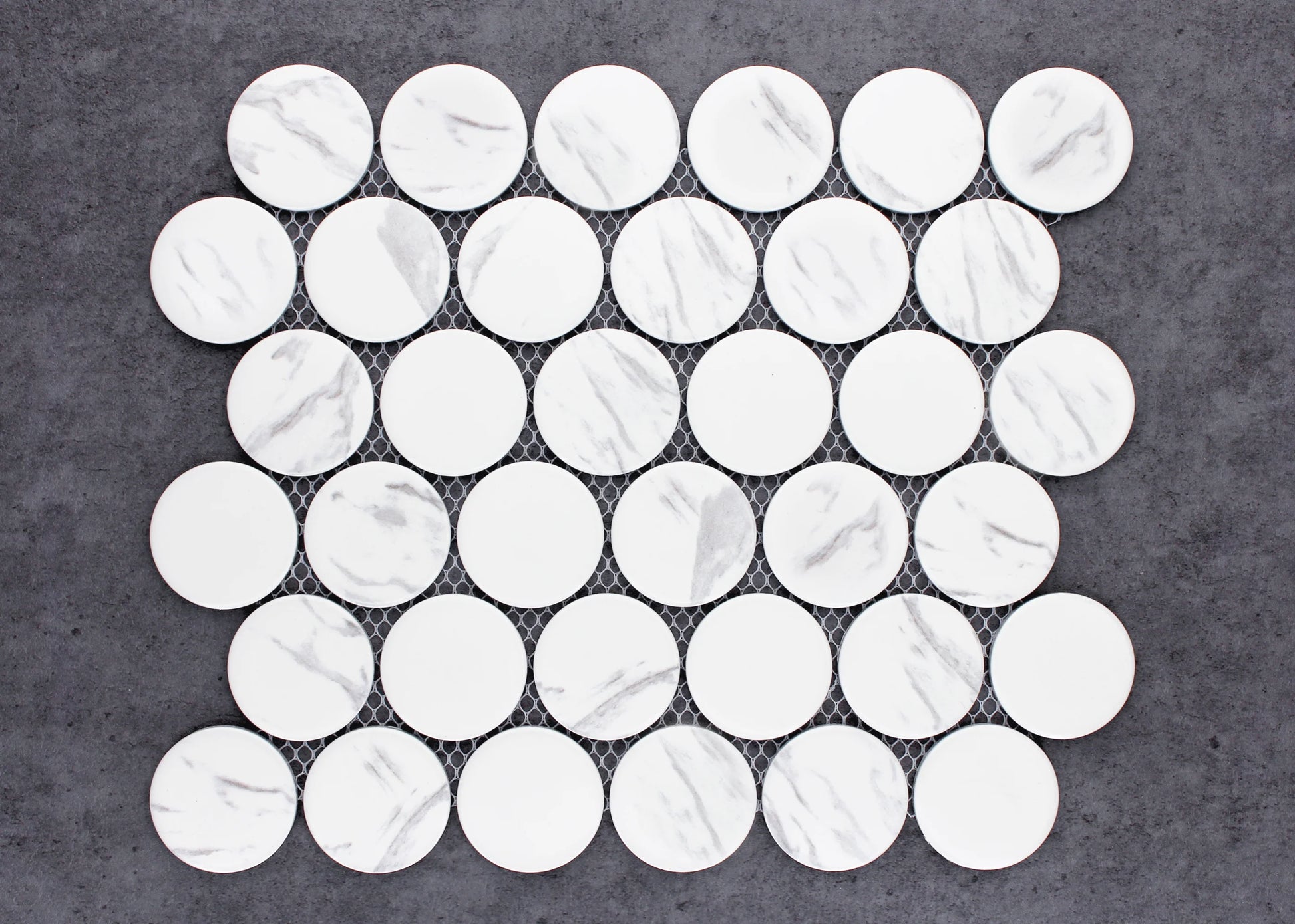 Carrara Look Matte Porcelain Glazed Penny Round 48mm tiles arranged on a mesh sheet, showing white matte circular tiles with subtle grey marble veining.