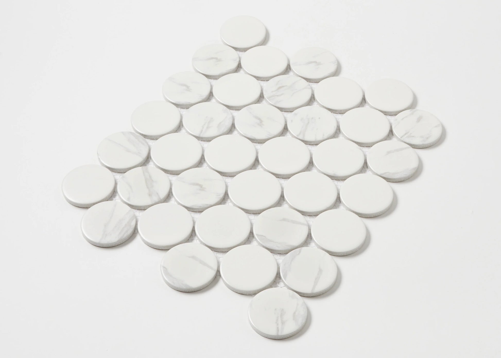 Carrara Look Matte Porcelain Glazed Penny Round 48mm tiles arranged in a diamond-shaped mosaic sheet, showing white glazed circular tiles with subtle grey marble veining.