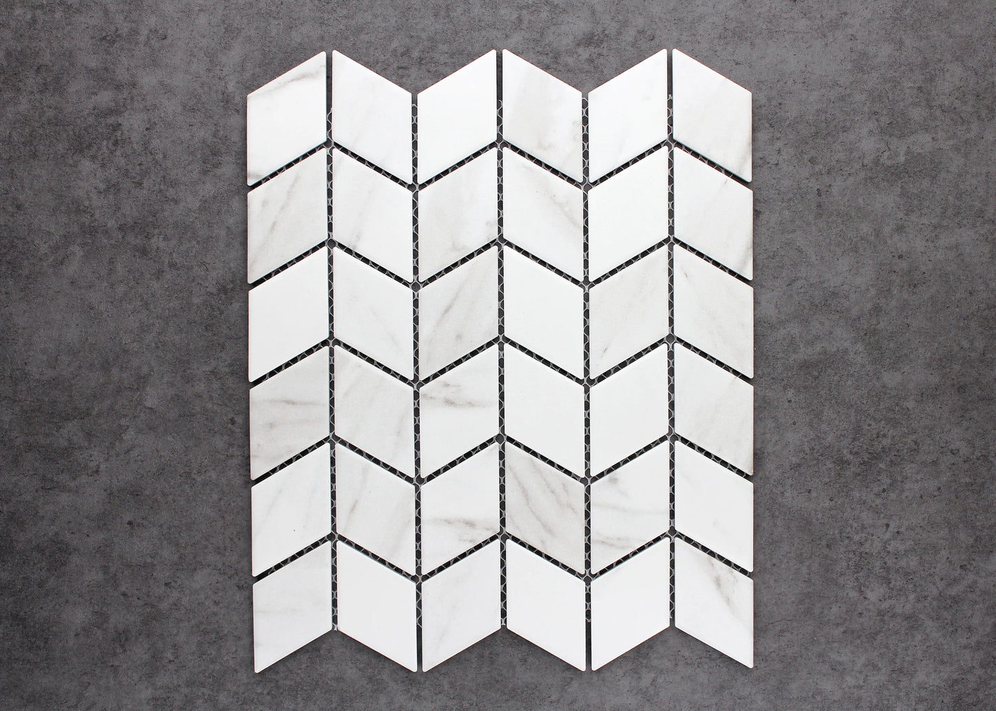 Pack shot of Carrara Look Matte Porcelain Glazed Rhombus 48x48mm tiles arranged in a chevron pattern, showcasing white marble-look veining and matte finish.