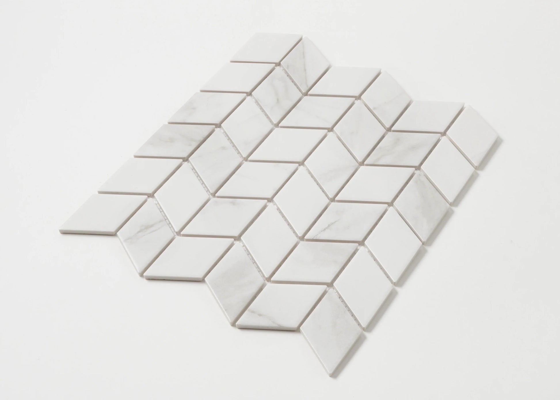 Pack shot of Carrara Look Matte Porcelain Glazed Rhombus 48x48mm tiles arranged in a diamond mosaic sheet showing white marble-look finish with subtle grey veining.
