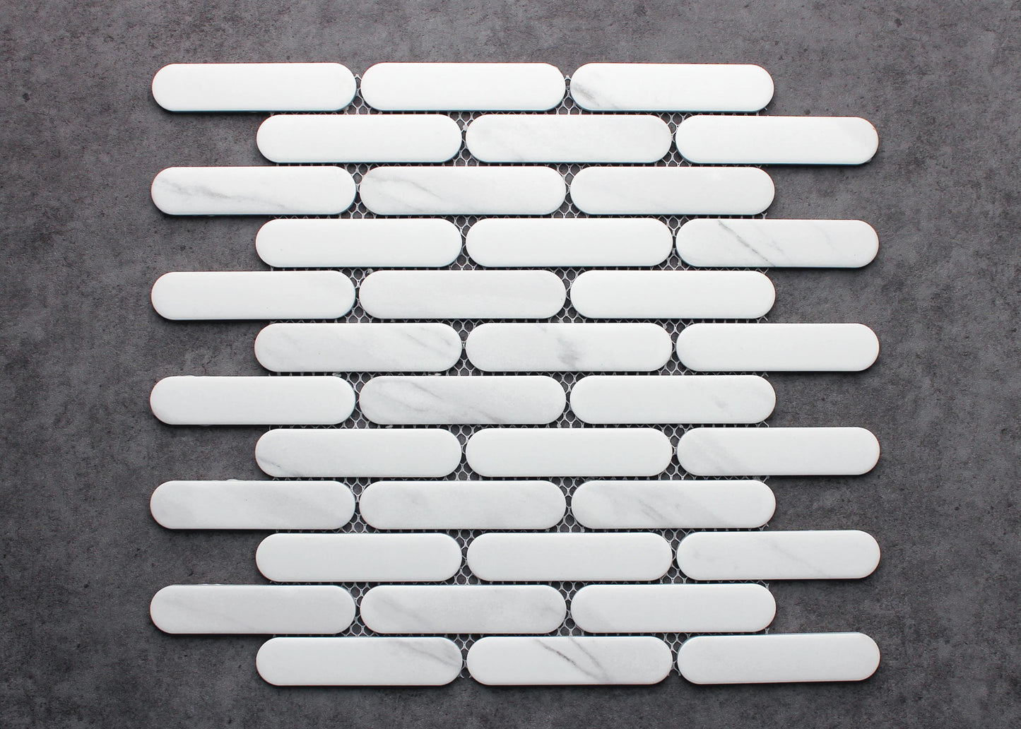 Carrara Matte Round Head Finger Glazed Mosaic 23x93mm tiles arranged on mesh backing sheet, showing white marble with subtle grey veining and rounded pill-shaped format.