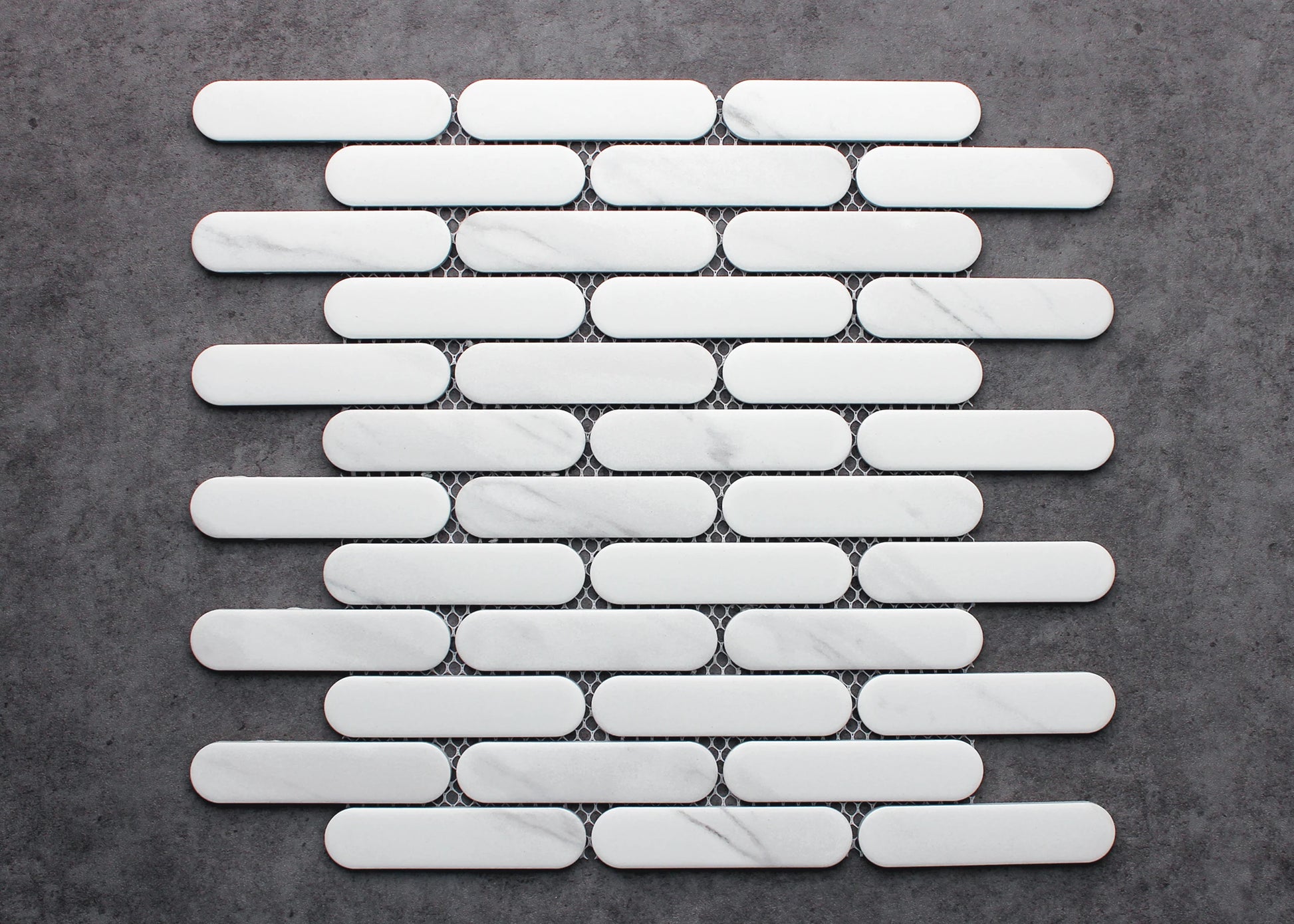 Carrara Matte Round Head Finger Glazed Mosaic 23x93mm tiles arranged on mesh backing sheet, showing white marble with subtle grey veining and rounded pill-shaped format.